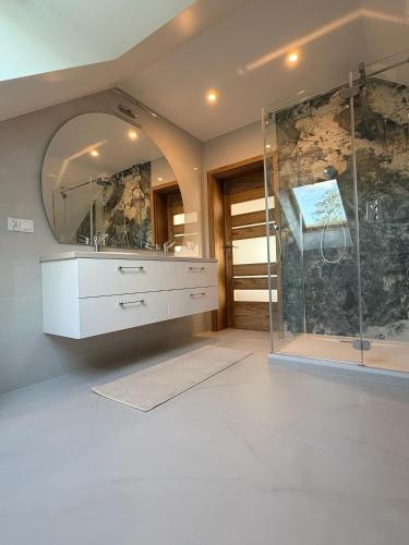 a bathroom with a glass shower and a sink at Willa Sielanka in Becejły