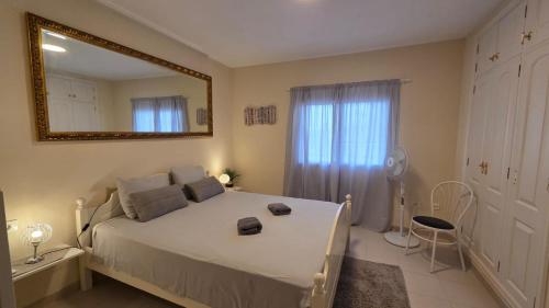 a bedroom with a large bed and a mirror at Callao Sun & Pool by Diamanteholidays in Callao Salvaje