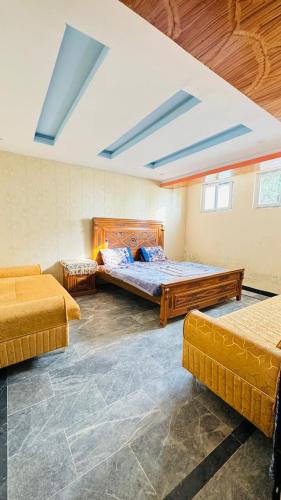 a bedroom with two beds and two couches at Mashal Palace in Nathia Gali