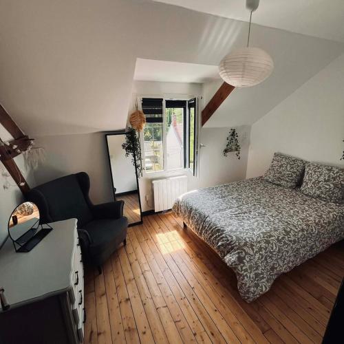 a bedroom with a bed and a couch and a window at Maison de caractère familiale in Béthisy-Saint-Martin