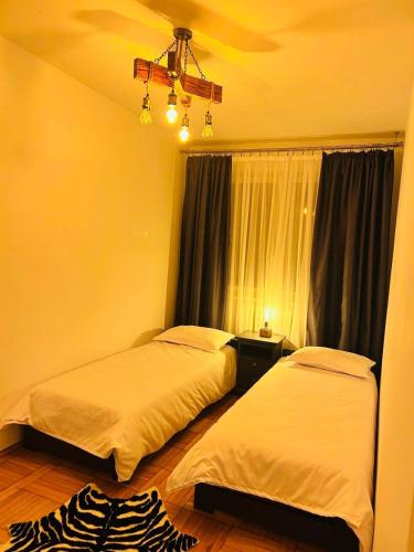 a bedroom with two beds and a ceiling fan at Wood&Light in Hunedoara
