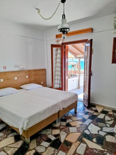 a bedroom with a bed and a large window at Lefteris Rooms in Kokkari