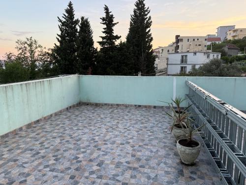 a balcony with a fence and potted plants at Green Villa in Šušanj