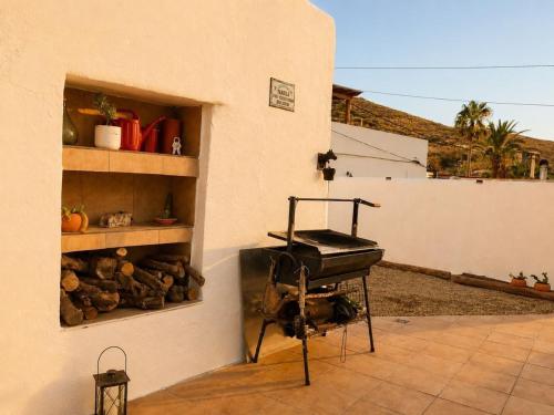 a barbecue grill sitting in the corner of a building at Refugio rural en Níjar con jardín privado barbacoa y solarium con vistas únicas in Níjar