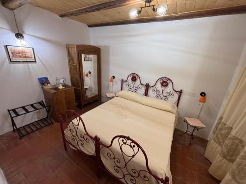 a bedroom with a bed and a table and a mirror at B&B Casa Doria in Castelsardo