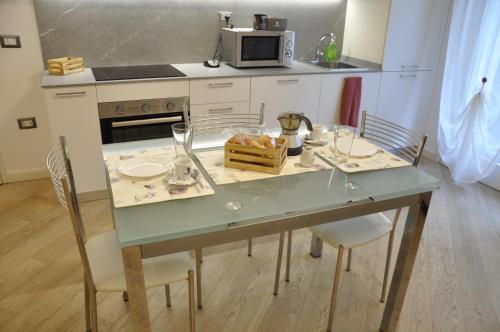a kitchen with a table with chairs and a microwave at Appartamento moderno e spazioso con giardino privato in Selvazzano Dentro