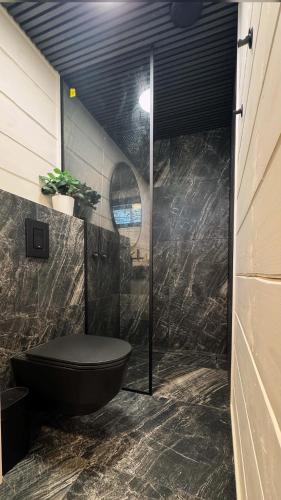 a bathroom with a black tub and a toilet at Ülesaare kämping in Kelnase