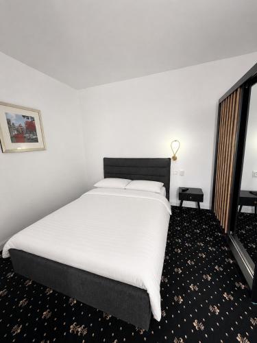 a bedroom with a large bed with white sheets at Rosetti Inn in Cluj-Napoca