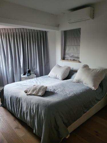 a bedroom with a large bed with white sheets and a window at Garden villa Raanana in Ra‘ananna