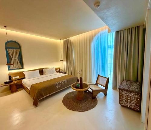 a hotel room with a bed and a chair at Iconic Mediterranean Hotel in Dhërmi