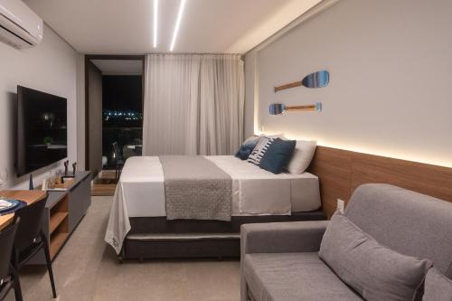 a hotel room with a bed and a couch at Beach Class Verano in Porto De Galinhas
