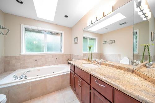 a bathroom with a tub and a sink and a bath tub at Forest house 4 bedrooms in Surrey