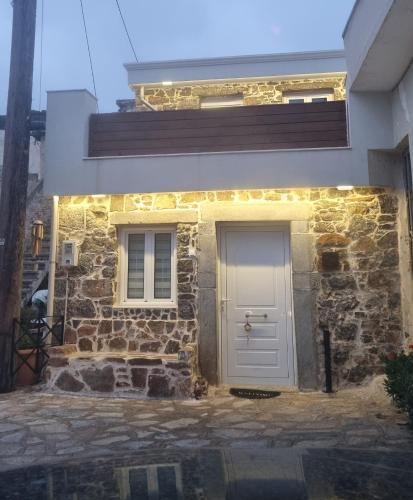 a white door on a stone house with lights at MENELAUS Stone House in Fourní