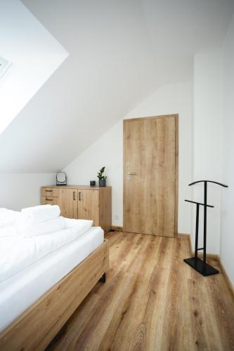 a bedroom with a bed and a wooden floor at Malé Lipno 1085 in Černá v Pošumaví