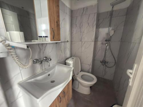 a bathroom with a sink and a toilet and a shower at FİNİKE SEVER OTEL in Finike