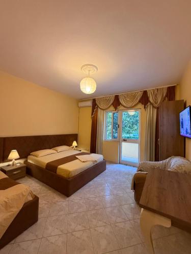 a large bedroom with two beds and a television at Vogli's House Apartments & Rooms in Durrës