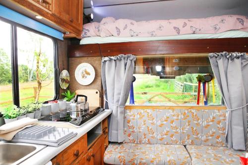 an rv kitchen with a stove and a sink at Tarka Trail Horsebox - Hot Tub & Pet proof garden in Littleham