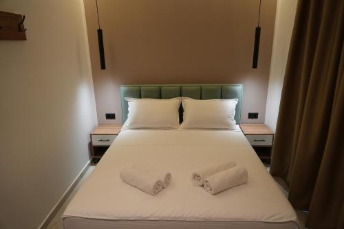 a bedroom with a bed with two towels on it at Summer Tale Rooms in Tale