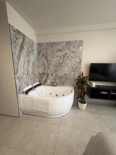 a white bath tub in a bathroom with a tv at Marilux oasi di relax in Marina di Carrara