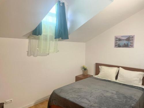 a bedroom with a bed and a window with blue curtains at Apartamento Centro das Furnas in Furnas