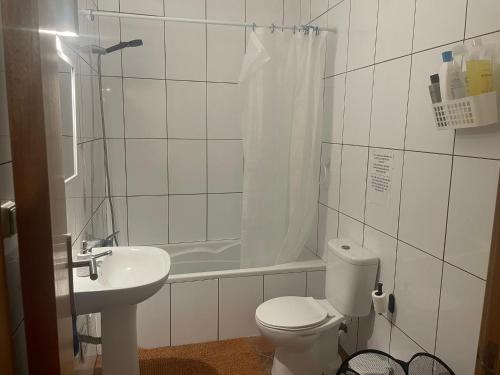 a bathroom with a toilet and a sink and a tub at Apartamento Centro das Furnas in Furnas