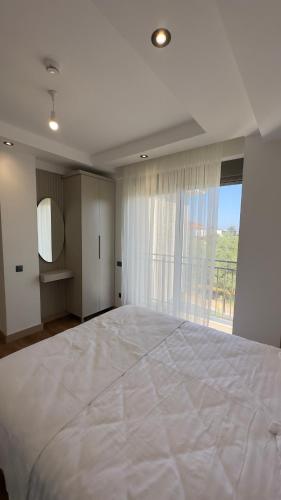 a large white bed in a room with a window at Nest Park Side in Side