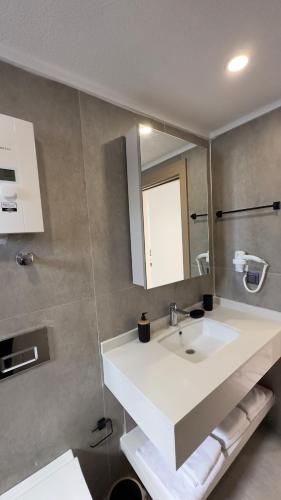 a bathroom with a white sink and a mirror at Nest Park Side in Side
