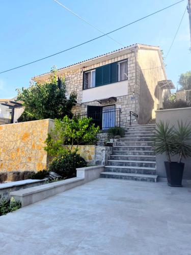 a house with stairs in front of a building at Apartman NONO in Splitska