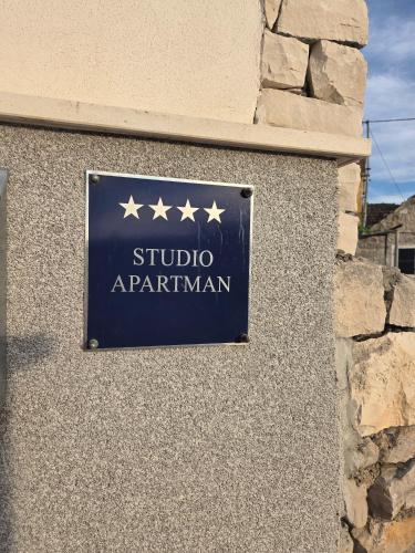 a sign on the side of a building with five stars at Apartman NONO in Splitska