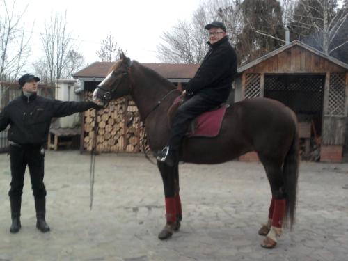 a man is sitting on a horse next to a man at Guest House Marketti in Vynohradiv