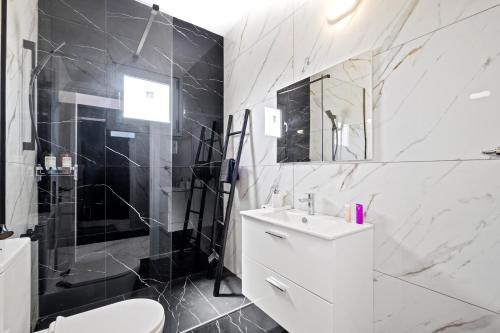 a bathroom with a toilet and a sink and a shower at Sea Breeze Studios in Pervolia