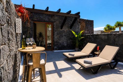 a patio with two chairs and a table at Villa Blanco - Romantic Hideaway - Private Villa for Couple in Tías