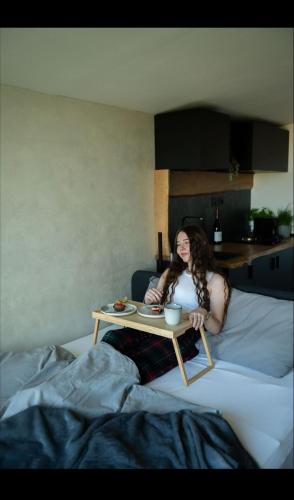 a woman sitting on a bed with a table at Posed pod hviezdami in Modra
