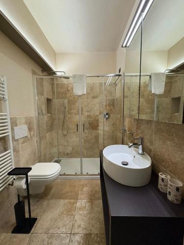 a bathroom with a sink and a shower and a toilet at Appartamento I 2 Archi in Siena