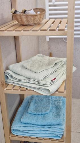 a wooden shelf with towels and a basket on it at Les Fougères in Sévrier