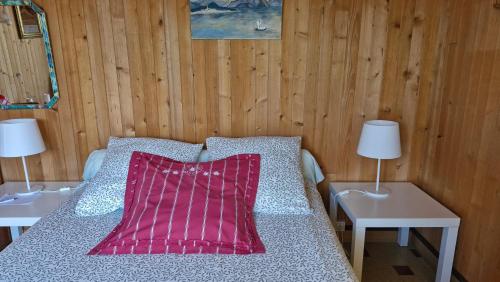 a bed in a room with two tables and two lamps at Les Fougères in Sévrier