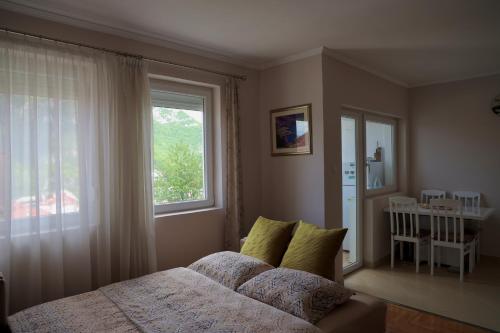 a bedroom with a bed and a large window at PivApart Plužine in Plužine