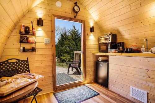 a room with a door leading to a kitchen in a log cabin at The Cranny at Kimberly Creek Retreat in Ashland