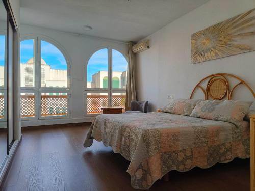 a bedroom with a bed and two large windows at La Casa de las Maravillas in Puerto de Mazarrón