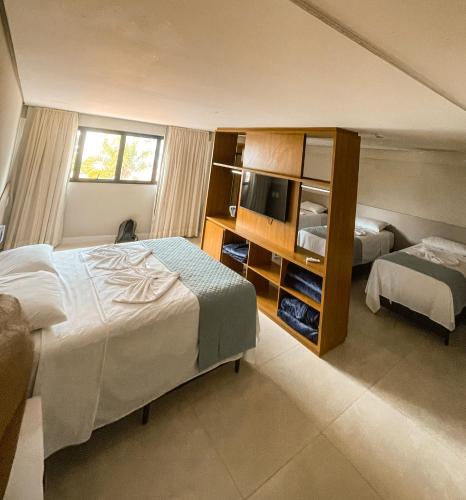 una camera d'albergo con due letti e una televisione di HIMMA Hotel a Aparecida