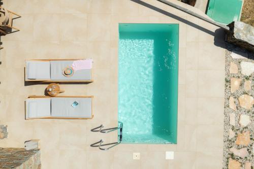 a swimming pool on the side of a building with a water fountain at Refoulia Eco Suites in Vathi