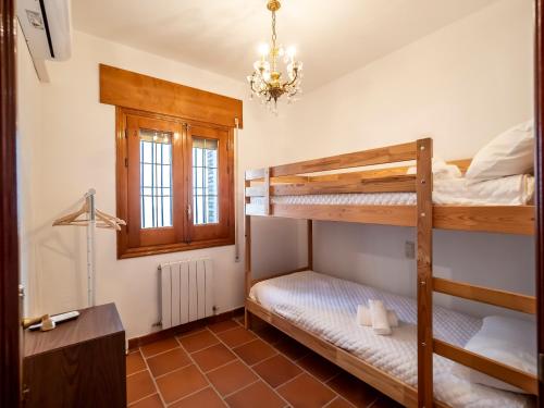 a bedroom with two bunk beds and a chandelier at Casa Dorrego Toledo in Cabañas de la Sagra