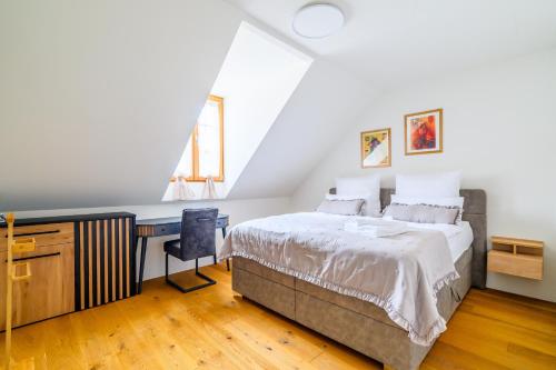 a bedroom with a bed and a desk and a window at Casa Rheinblick - Apartment D in Basel