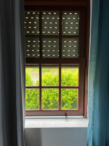 a window with a view of a green field at Azul 31 in Lajes das Flores