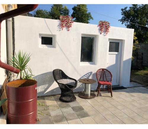 a patio with chairs and a table and a building at Guest house with sauna in Krčedin