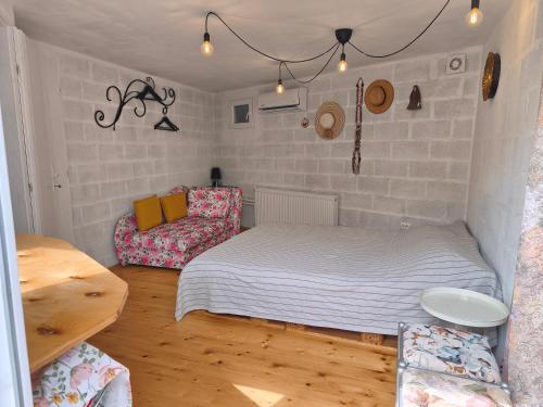 a small bedroom with a bed and a chair at Guest house with sauna in Krčedin