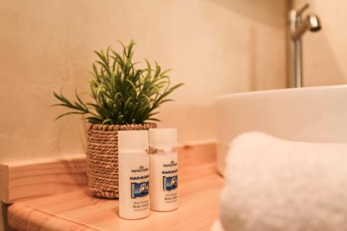 two bottles of sunscreen on a table with a potted plant at Little escape in episkopi-heraklion