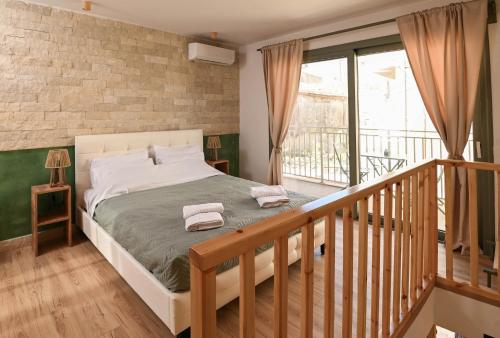 a bedroom with a bed and a balcony at Little escape in episkopi-heraklion