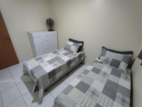a bedroom with two beds and a dresser at Excelente Apartamento in Buíque