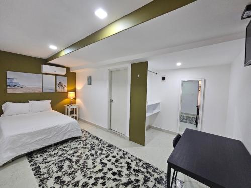 a bedroom with a bed and a table and a desk at Malecon Premium Rooms & Hotel in Santo Domingo